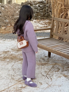 Detail of purple knitted toddler set featuring a stylish mini tote bag with embroidery