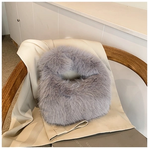 Détail de la texture d'un sac cabas en fausse fourrure gris clair doux sur fond neutre