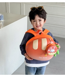 Detail of cute orange bunny carrot backpack for kids with a round coin purse charm
