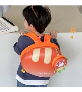 Detail view of children's EVA bunny backpack with carrot charm and padded orange straps