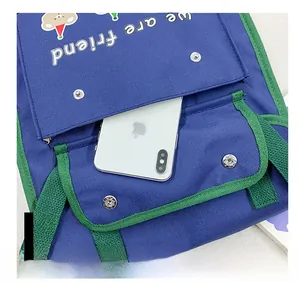 Close-up of canvas backpack front pocket with cartoon bear print and button closure
