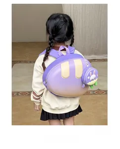 Detail view of purple gradient hardshell kids backpack with cute bunny charm on child