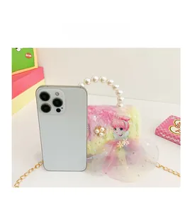 Mini rainbow plush bag shown with a smartphone to illustrate the compact portable size