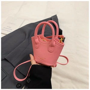Detailed macro view of pink mini tote bag with litchi grain texture and gold zippers