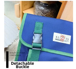 Detail of child backpack showing detachable plastic buckle and durable blue canvas fabric