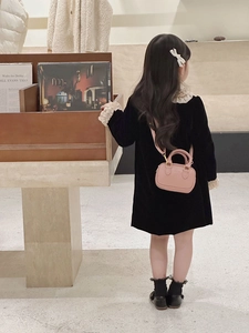 Detail der rosa Mini-Kinder-Bowlingtasche getragen von einem Model im Samtkleid