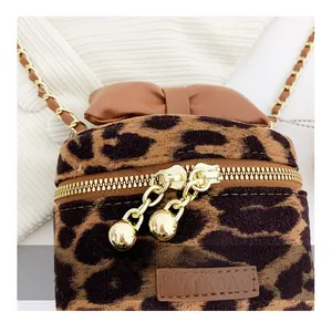 Detail showing the leopard print fabric, smooth golden zipper, and decorative bow on the bag