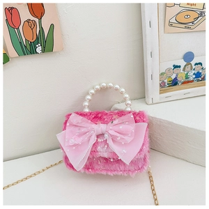 Détail du mini sac en peluche rose avec nœud en résille, anse perle et chaîne dorée