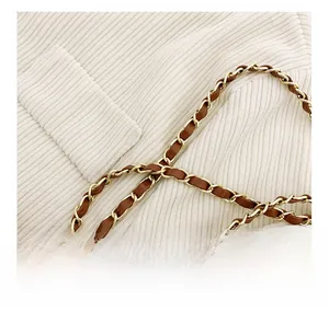 Macro shot of gold metal chain woven with brown leather strap for kid's handbags