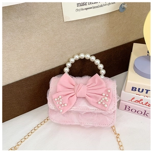 Detail of pink mini bag with large bow and pearl handle for girls' fashion style
