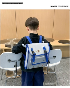 Detail of a kids' backpack with contrasting grey and blue colors and cute bear patch