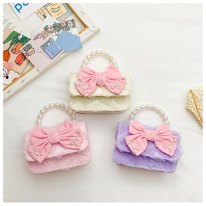 Close-up of kids mini bags featuring lace texture, pearl handles and large pink bows