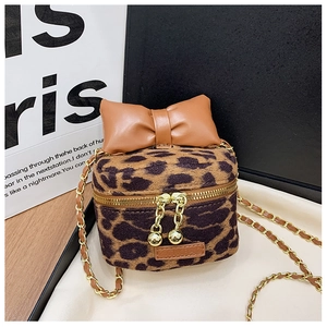 Detail view of mini leopard print kid's crossbody bag with brown bow and gold chain strap