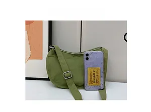 Green nylon crescent shoulder bag size comparison with a smartphone on a white surface