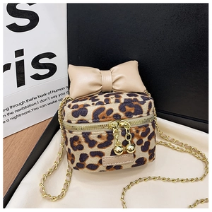 Detail of leopard print crossbody bag with beige bow, gold zippers and chain strap