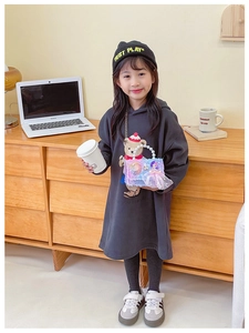 Detail of grey girl's hoodie with plush purple pearl-handle bag and embroidered beanie