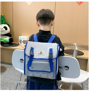 Close-up of kids bear backpack featuring blue double buckles and contrast colors