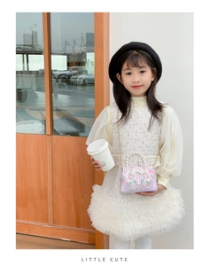 Détail de robe en tweed, sac à main avec poignée en perles et béret noir pour fille