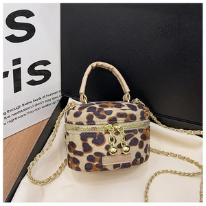 Detail of leopard print mini cylindrical bag with gold chain strap in a premium gift box
