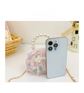 Détails de broderie florale avec poignée en perles et chaîne sur petit sac rose