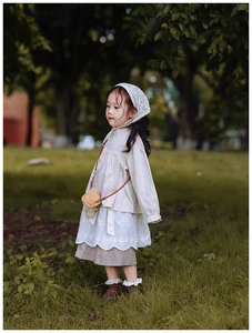Détail de tenue style forêt vintage pour fille avec dentelle brodée et accessoires en tricot