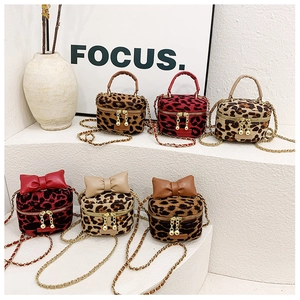 Detailed view of leopard print mini crossbody bags with bows and gold chains