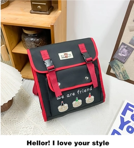 Close-up of bear graphic and we are friend slogan on kids backpack with red buckle