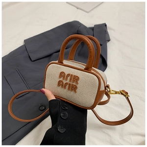 Detail of mini canvas tote with brown leather trim and Arir Arir embroidery