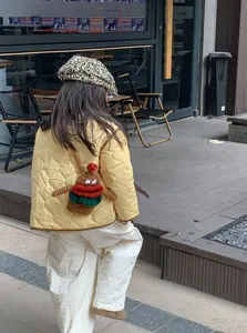 Outdoor view of child wearing a leopard print beret and a brown crochet doll crossbody bag