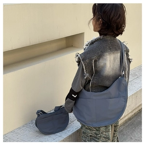 Detailed view of the dark blue crescent crossbody bag with premium stitching and texture