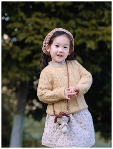 Détail d'un cardigan en maille jaune avec sac champignon et béret crochet pour enfant