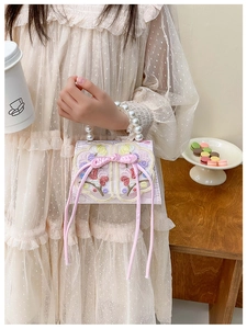 Détail du sac brodé pour fille avec poignée en perles et nœud traditionnel rose