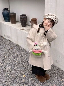 Detail of crochet crossbody bag with sausage lips on child beige duffle coat outfit