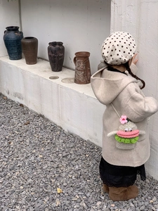 Cute crochet baby crossbody bag with cartoon face and floral details for winter