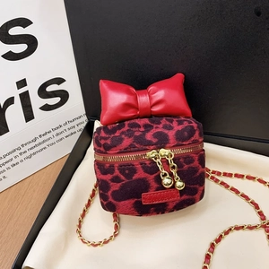 Kids leopard print crossbody bag with large red bow and gold chain strap on gift box