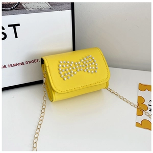 Detail of yellow mini crossbody bag with pearl bow decoration and golden metal chain