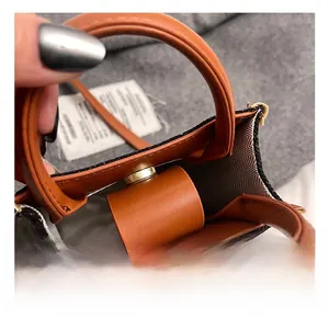 Detail of children's leather crossbody bag with golden hardware and herringbone lining