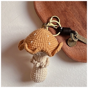 Détail du porte-clés champignon au crochet avec bonnet orange et pendentifs en métal