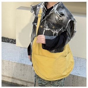 Detail of bright yellow canvas crescent bag with pockets and adjustable shoulder strap