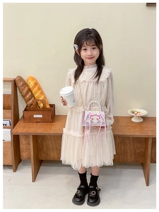 Détail d'une robe en tulle beige avec un sac à main brodé de perles pour fillettes