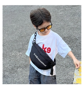 Détail du sac de poitrine noir pour enfant avec lettrage blanc et grosse chaîne