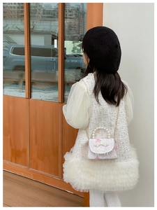 Détail d'une fille en robe de tweed avec manches bouffantes et sac à perles