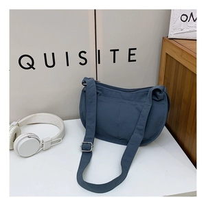 Detail of blue nylon crescent crossbody bag with adjustable strap and front pocket