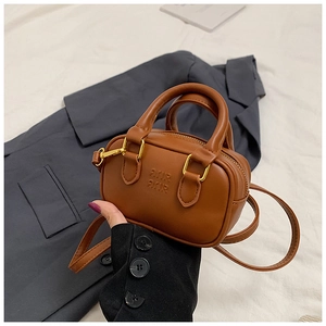 Detail einer mini braunen Kunstleder-Boston-Tasche mit Henkeln und Logoprägung