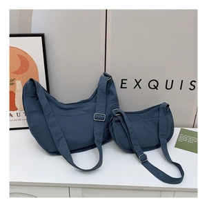 Detail of grey-blue nylon crescent bags in two sizes with adjustable shoulder straps
