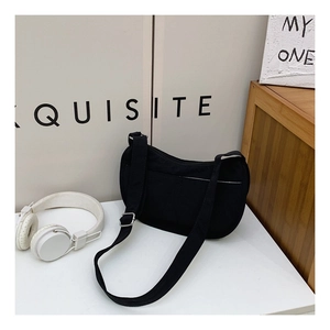 Detail of black canvas crescent bag showing thick texture and adjustable strap