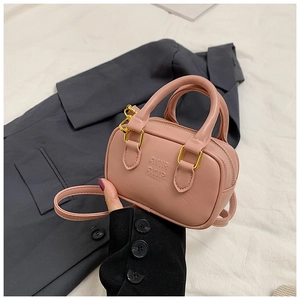 Makroansicht einer rosa Mini-Handtasche aus mattem Leder mit Prägung und Goldreißverschluss