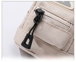 Detailed close-up of a sturdy black zipper head on a khaki canvas mini tactical pouch