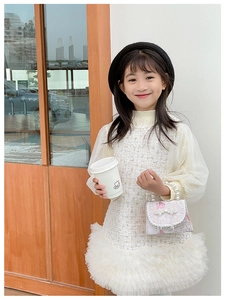 Détail d'une robe en tweed pour fille avec manches en tulle et sac à main en dentelle