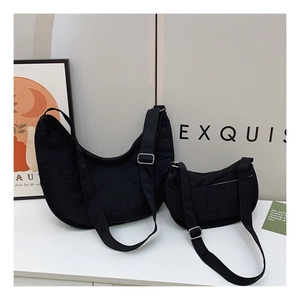 Detail view of black crescent nylon bags in two sizes with adjustable silver buckle straps